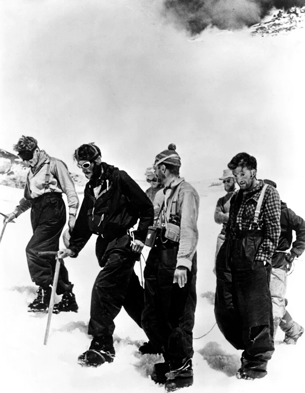 Ancak Everest’in zirvesine ulaşan bu iki ismin hikâyesi, yalnızca bir dağa tırmanmaktan ibaret değildi. Yıllar süren keşifler, başarısız girişimler, ağır yükler taşıyan dağ işçilerinin emeği ve insanın sınırlarını zorlama kararlılığı, bu tarihî başarının arkasında yer alıyordu.