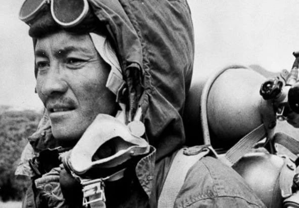 Tenzing Norgay, Everest’in bulunduğu Himalaya coğrafyasıyla güçlü bir bağa sahipti. Şerpa topluluğundan gelen Norgay, genç yaşlardan itibaren dağcılık seferlerinde çalıştı; yüksek irtifada hareket etmeyi, ağır yük taşımayı ve dağın değişken koşullarını tanımayı öğrendi.

O dönemde Batılı keşif ekiplerinin başarıya ulaşabilmesi, bölgeyi iyi bilen Şerpa dağcıların deneyimine büyük ölçüde bağlıydı. Yüksek kamplara malzeme taşımak, güzergâh açmak, ipleri sabitlemek ve tırmanış ekiplerine destek vermek, seferlerin en önemli parçaları arasındaydı.

Norgay, Everest’e ulaşmayı yalnızca bir iş olarak görmüyordu. Yıllar boyunca farklı seferlerde yer aldı ve zirveye ulaşma hedefini sürdürdü. Dağın yüksek kesimlerinde edindiği deneyim, 1953’teki tarihî girişimin en önemli avantajlarından biri olacaktı.